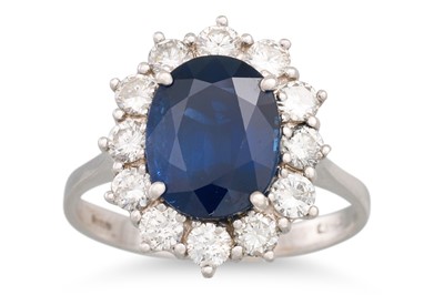 Lot 215 - A SAPPHIRE AND DIAMOND CLUSTER RING, the oval...