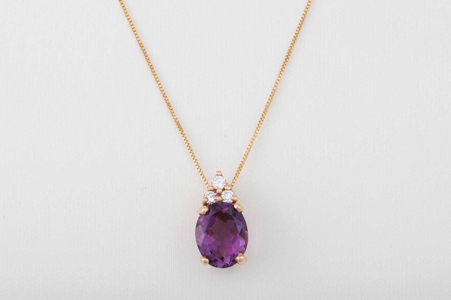 Lot 55 - AN AMETHYST AND DIAMOND PENDANT, the oval...