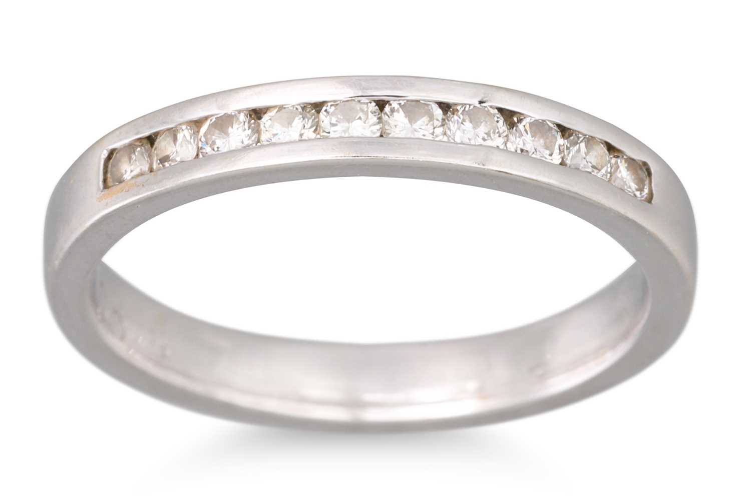 Lot 29 - A DIAMOND CHANNEL SET BAND RING, ten round...