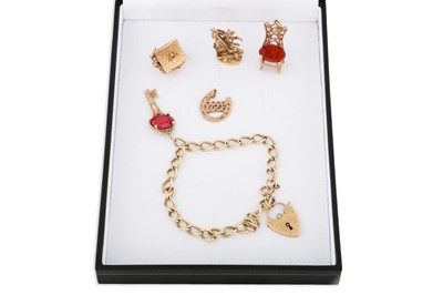 Lot 135 - A 9CT GOLD CHARM BRACELET, various charms, 33 g.