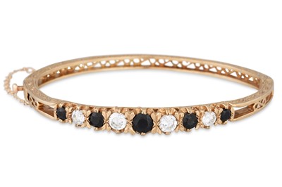 Lot 12 - A 9CT GOLD HINGED BANGLE, stone set with...