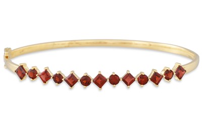 Lot 139 - A GARNET AND GOLD HINGED BANGLE, the round and...