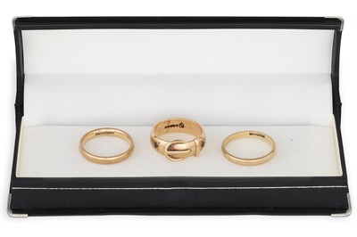 Lot 175 - A 9CT GOLD BUCKLE RING, together with two band...