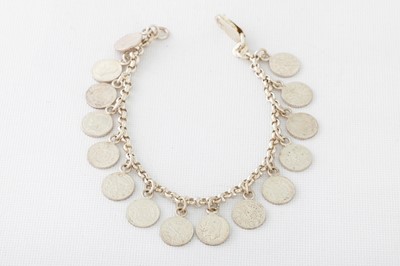 Lot 153 - A SILVER CHARM BRACELET, suspending coin charms