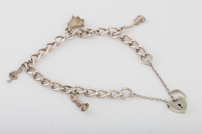 Lot 389 - A STERLING SILVER CURB LINK CHARM BRACELET,...