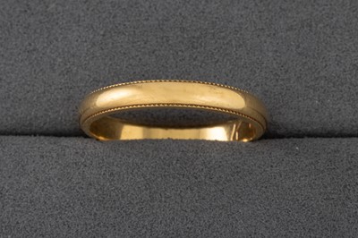 Lot 85 - AN 18CT YELLOW GOLD WEDDING BAND, with beaded...