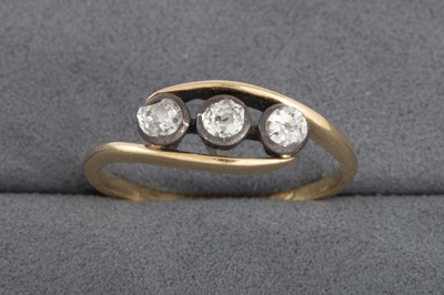 Lot 68 - A VINTAGE THREE STONE DIAMOND TWIST RING, in...