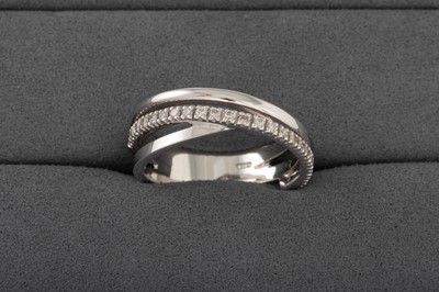 Lot 150 - A VINTAGE DIAMOND CROSS OVER RING, mounted in...