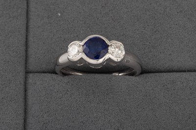 Lot 180 - A DIAMOND AND SAPPHIRE THREE STONE RING, the...