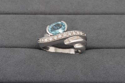 Lot 22 - A DIAMOND AND AQUAMARINE RING, of cross over...