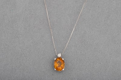 Lot 49 - A CITRINE AND DIAMOND PENDANT, the oval...