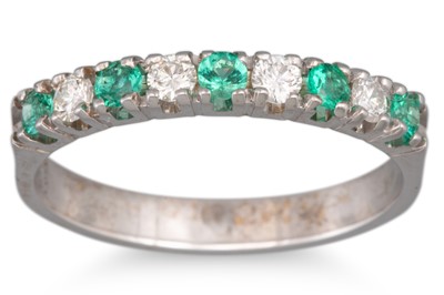 A DIAMOND AND EMERALD HALF ETERNITY RING, set...