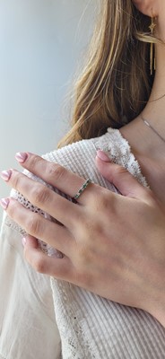 A DIAMOND AND EMERALD HALF ETERNITY RING, set...