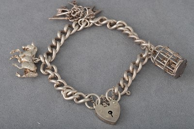 Lot 186 - A SILVER CURB LINK CHARM BRACELET, with...