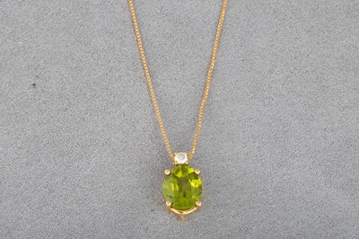 Lot 111 - A PERIDOT AND DIAMOND PENDANT, the oval...