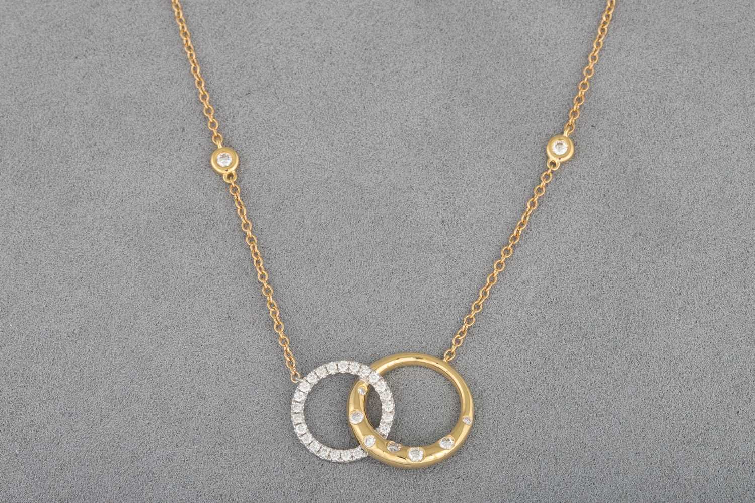 Lot 14 - A DIAMOND SET PENDANT, modelled as two...