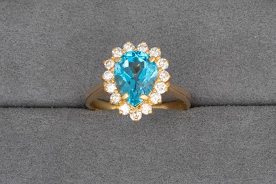 Lot 21 - A TOPAZ AND DIAMOND CLUSTER RING, the pear...