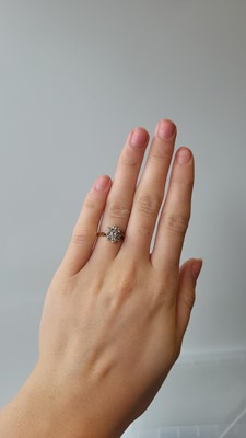 Lot 53 - A DIAMOND DAISY CLUSTER DRESS RING, mounted in...