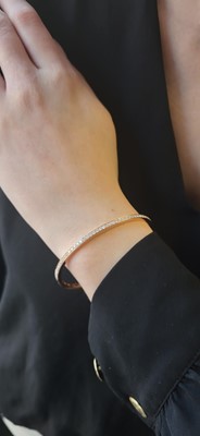 Lot 223 - A DIAMOND SET BANGLE, the brilliant cut...
