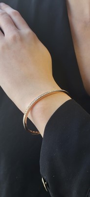Lot 223 - A DIAMOND SET BANGLE, the brilliant cut...