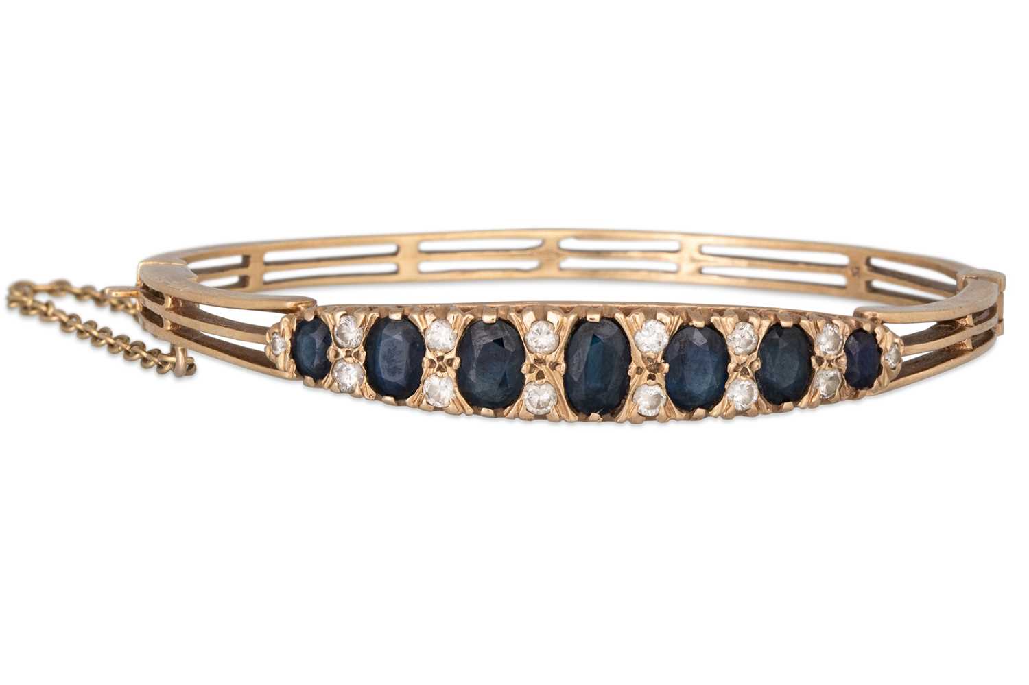 Lot 117 - A SAPPHIRE AND DIAMOND BANGLE, mounted in 9ct...