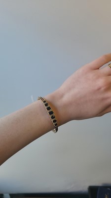 Lot 117 - A SAPPHIRE AND DIAMOND BANGLE, mounted in 9ct...