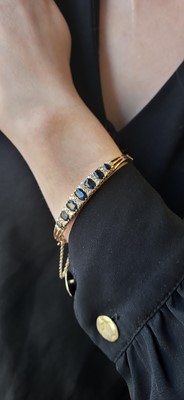 Lot 117 - A SAPPHIRE AND DIAMOND BANGLE, mounted in 9ct...