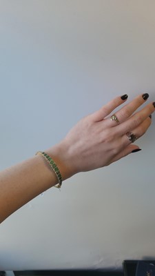 Lot 118 - AN EMERALD AND DIAMOND BANGLE, mounted in...
