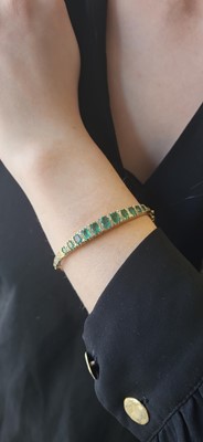 Lot 118 - AN EMERALD AND DIAMOND BANGLE, mounted in...