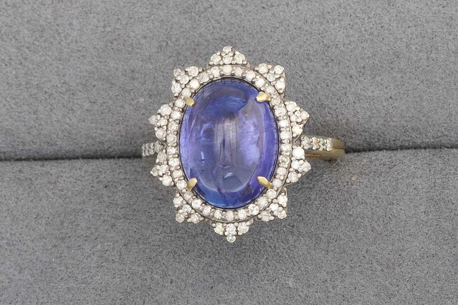 Lot 72 - A CABOCHON TANZANITE AND DIAMOND CLUSTER RING,...