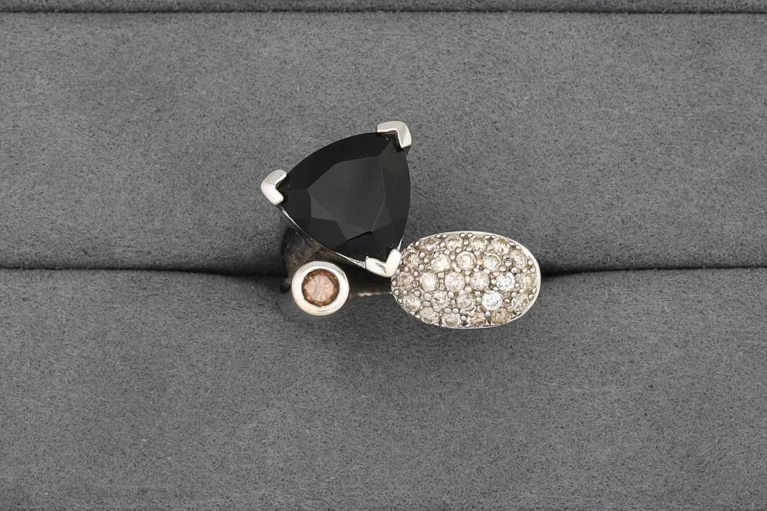 Lot 61 - A DIAMOND AND ONYX RING, of crossover form,...