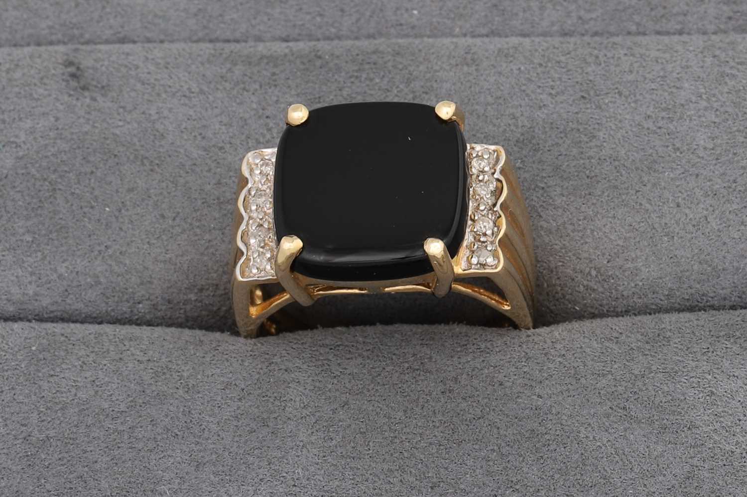 Lot 62 - AN ONYX RING, to diamond shoulders, mounted in...