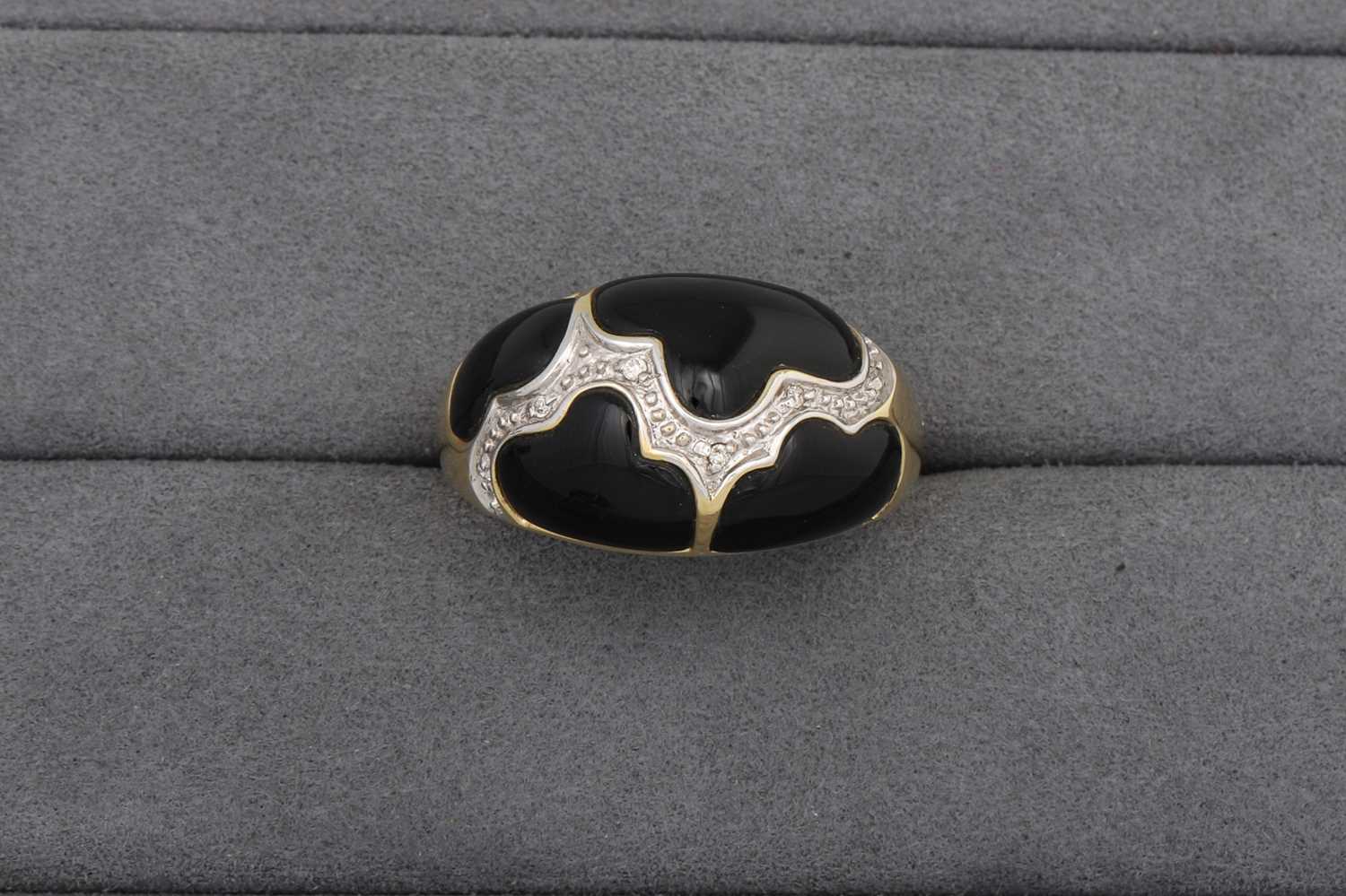 Lot 63 - AN ONYX AND DIAMOND BOMBE RING, mounted in...