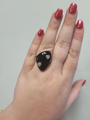 Lot 64 - AN ONYX PLAQUE RING, diamond detail, mounted...