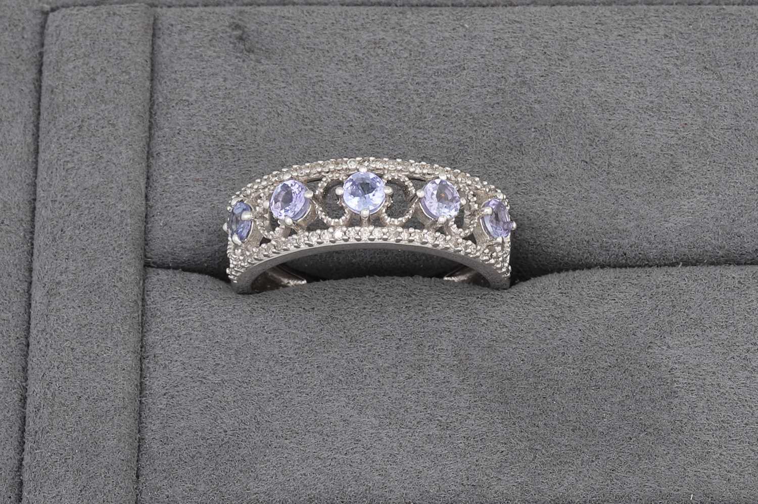 Lot 71 - A TANZANITE AND DIAMOND BAND RING, mounted in...