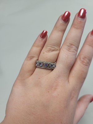 Lot 71 - A TANZANITE AND DIAMOND BAND RING, mounted in...