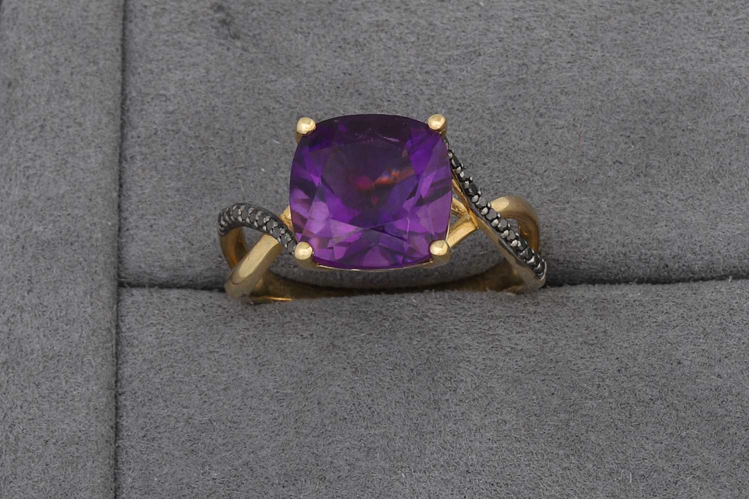 Lot 73 - AN AMETHYST SINGLE STONE RING, to black...