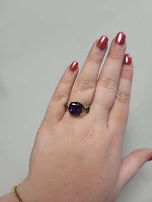 Lot 73 - AN AMETHYST SINGLE STONE RING, to black...