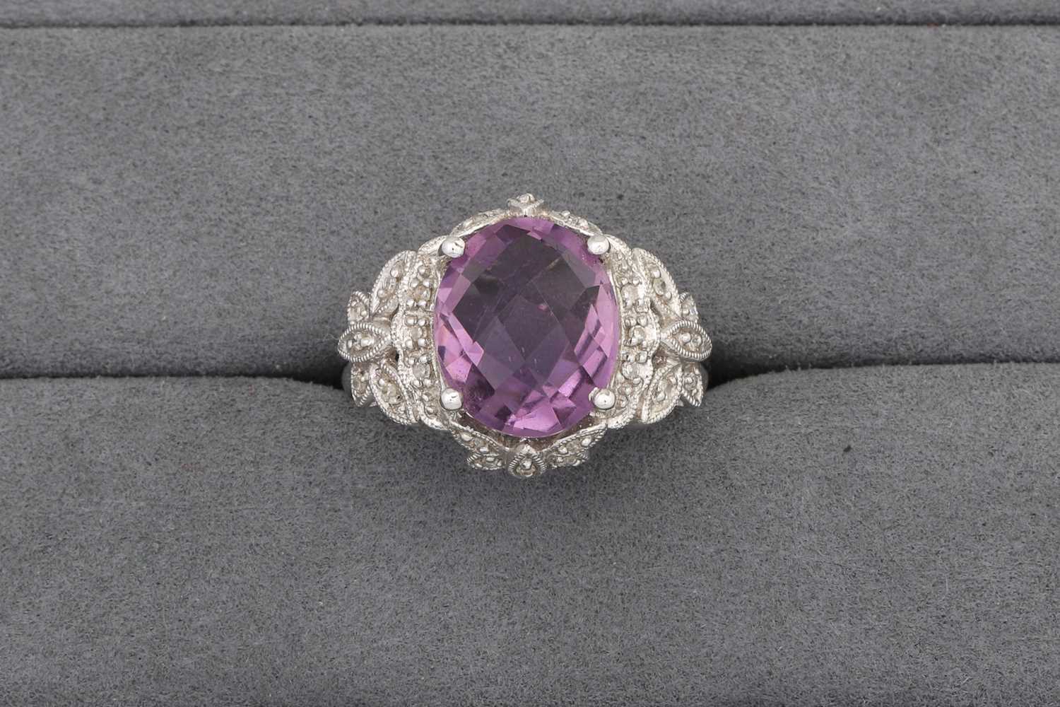 Lot 78 - AN AMETHYST RING, to diamond surround and...