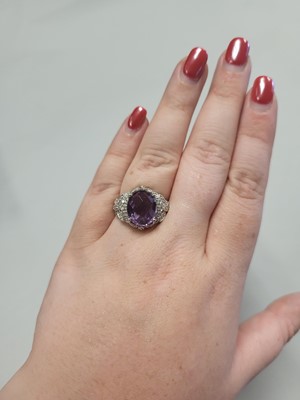 Lot 78 - AN AMETHYST RING, to diamond surround and...