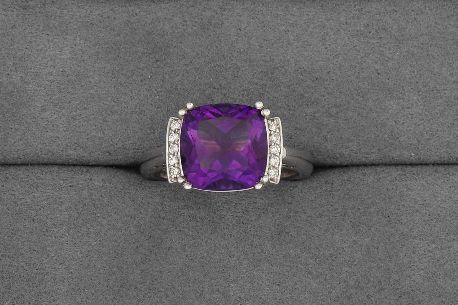 Lot 80 - A CUSHION-SHAPED AMETHYST RING, to diamond...