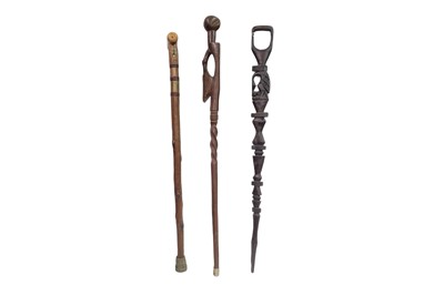 Lot 634 - THREE CARVED WOODEN WALKING STICKS, two...