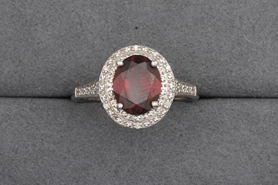 Lot 93 - A GARNET AND DIAMOND CLUSTER RING, mounted in...