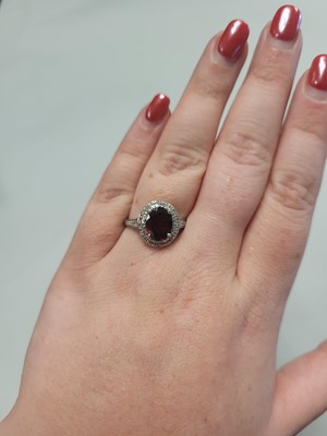 Lot 93 - A GARNET AND DIAMOND CLUSTER RING, mounted in...