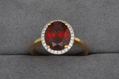 Lot 95 - A GARNET AND DIAMOND CLUSTER RING, mounted in...