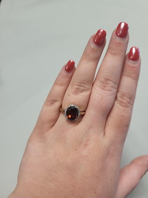 Lot 95 - A GARNET AND DIAMOND CLUSTER RING, mounted in...