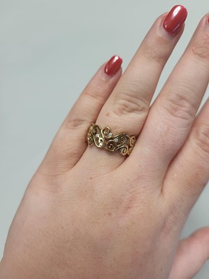 Lot 99 - A DIAMOND SET BAND RING, of scrolled design,...