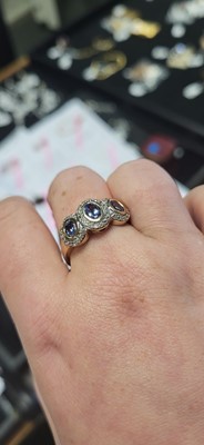 Lot 19 - A THREE STONE CLUSTER RING, set with...