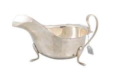 Lot 502 - A SILVER HELMET SHAPE SAUCE BOAT, on three out...