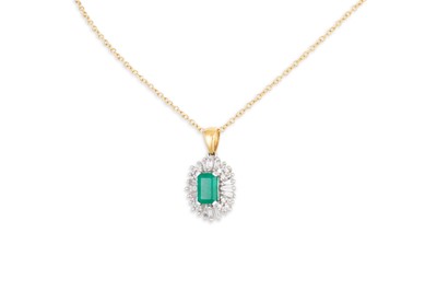 Lot 211 - AN EMERALD AND DIAMOND CLUSTER PENDANT, oval...